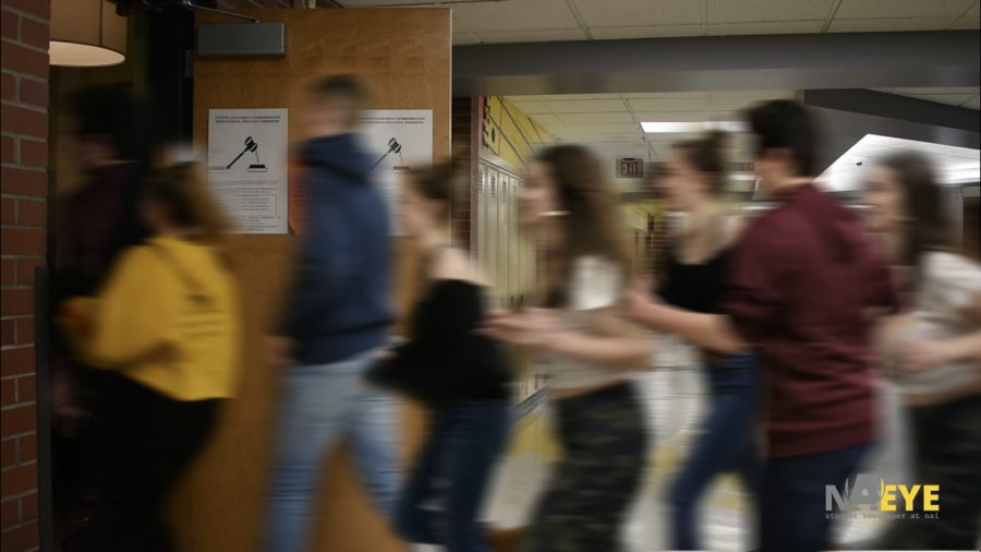 A mob of students hurriedly rush into a room as an active shooter drill is announced. 