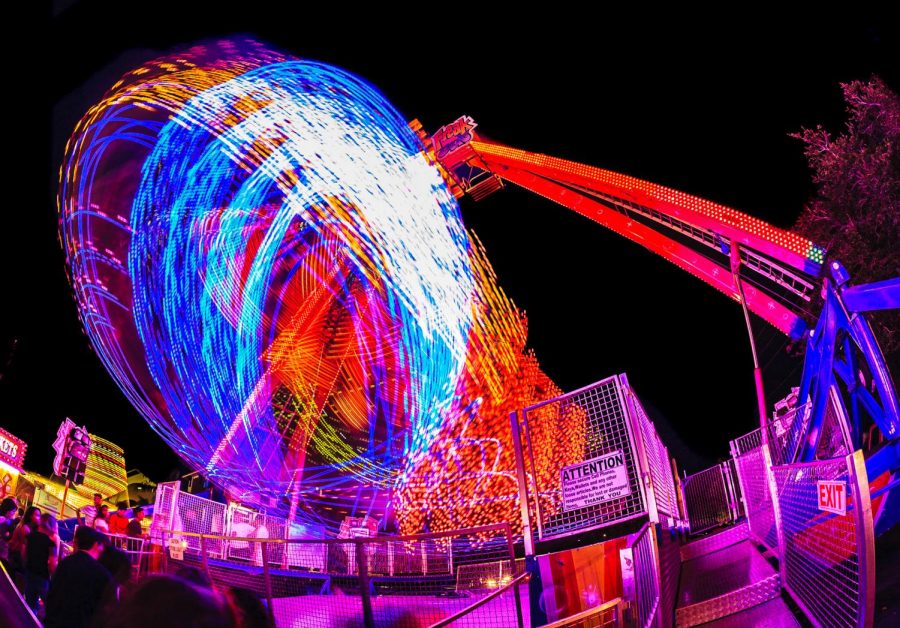Photo of a carnival ride with neon lights taken at night