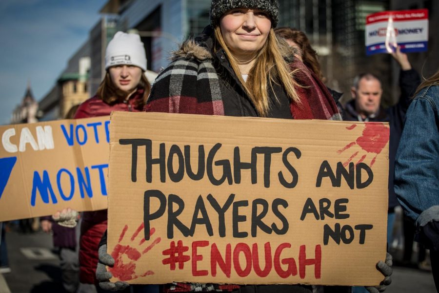 A sign rejecting thoughts and prayers at March For Our Lives.