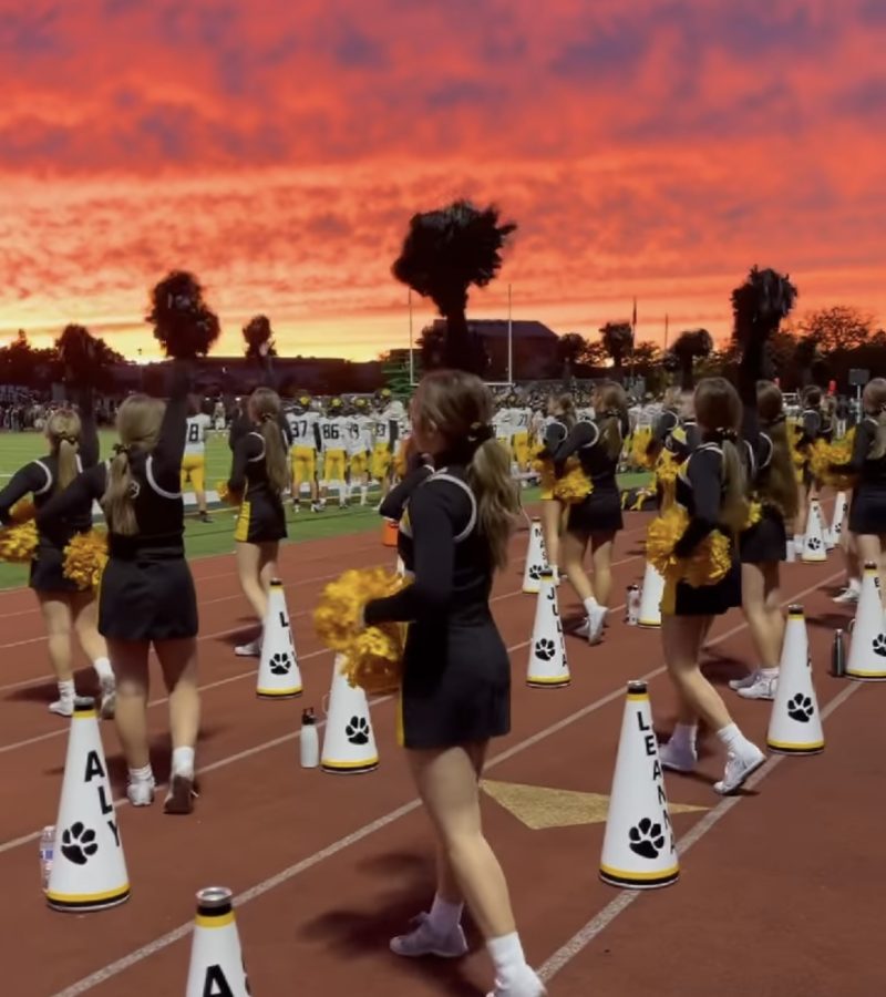 The NA Cheer team performs on the sidelines at Newman Stadium