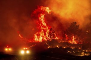 Flames leap above fire vehicles on the highway